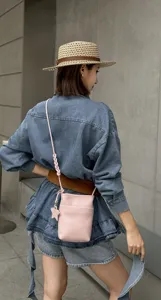 Detailed view of genuine leather pink mini crossbody phone bag with cute star charm accessory.