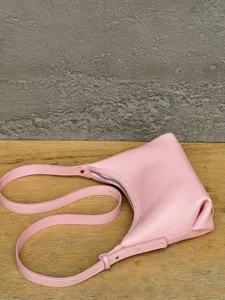 Detail view of the pink genuine leather hobo shoulder bag with zipper and strap.