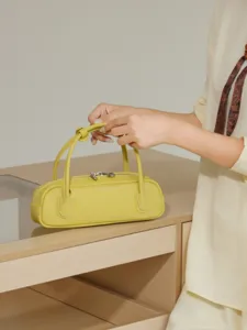 Yellow leather baguette bag women stylish cylinder shoulder handbag with double handles.
