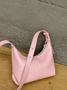 Pink genuine leather hobo bag detail, soft texture surface, adjustable shoulder strap.