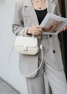 Borsa a mano da donna in vera pelle, dettaglio di tracolla chic per outfit eleganti e moderni.