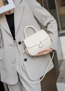 Primo piano dettagliato della borsa a mano beige in pelle con raffinata chiusura.