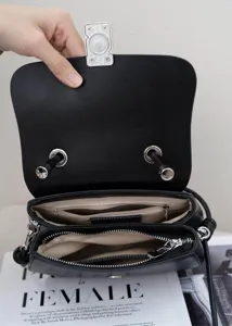Borsa a tracolla classica in pelle nera con vari scomparti interni e serratura in metallo.