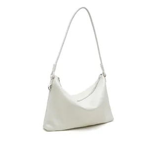 Detailed view of minimalist white leather shoulder bag with fine strap and smooth zipper closure.