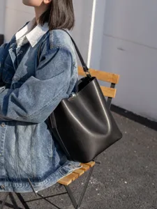 Minimalist black leather bucket bag for women, large capacity casual shoulder daily use.