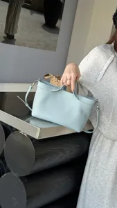 Light blue leather shoulder crossbody handbag detail, showcasing fine texture and hardware.