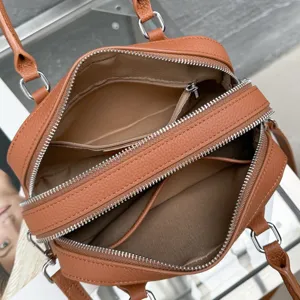Vue détaillée de l'intérieur du sac boston en cuir marron avec doubles fermetures.
