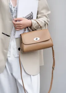 Nahaufnahme der kamelbraunen Schultertasche aus Leder mit Metallschloss und verstellbarem Riemen.