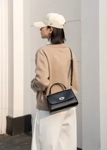 Detailansicht der schwarzen Leder Umhängetasche mit elegantem Metallschloss und Henkel.