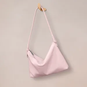 Pink leather shoulder bag for women, minimalist commuter hobo handbag with smooth zipper closure.