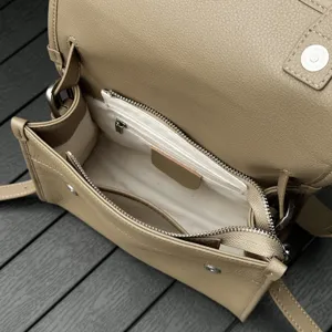 Genuine leather crossbody bag interior detail showing zipper pocket and soft lining structure.