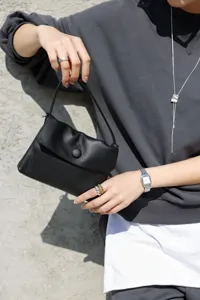 Genuine cowhide leather small top-handle handbag, elegant black design for women commuting.