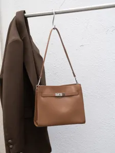 Bolso de hombro marrón retro para mujer con cierre metálico, elegante detalle de bolso tote.