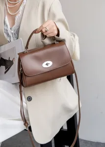 Braune Leder Schultertasche Detail, eleganter metallischer Drehverschluss Stil.
