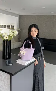 Elegant genuine leather bucket bag for women, stylish top handle shoulder bag detail.