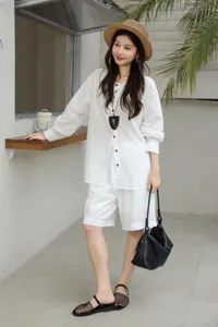 Vista dettagliata della borsa a spalla hobo in pelle nera in un outfit casual.