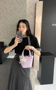 Detailed shot of light purple leather bucket bag with lock charm, casual daily style view.