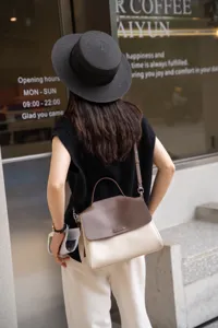 Leather crossbody shoulder bag detail, stylish two-tone brown and beige casual commuter handbag.