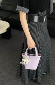 Elegant leather bucket bag featuring a cute bear pendant, perfect for daily style and casual use.
