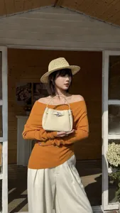 Mini cowhide leather handbag with metallic closure and top handle, elegant daily fashion style.