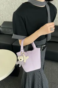Genuine leather bucket bag for women, stylish handbag with cute charm, elegant design.