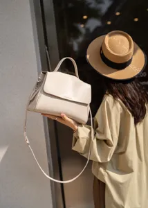 Detailed view of the elegant beige genuine leather top-handle shoulder bag with chic design.