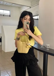 Genuine leather yellow bucket bag for women, chic minimalist handbag with cute bear charm.