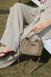 Mini taupe leather bucket bag, chic top handle crossbody bag for women, stylish everyday wear.