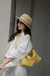 Borsa a spalla hobo minimalista in morbida pelle bovina vista dettagliata, stile elegante.