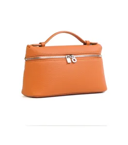Dettaglio borsa vanity in pelle arancione con manico elegante e doppia zip argentata.