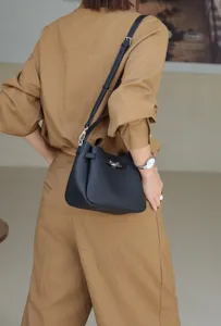 Mini leather bucket shoulder bag for women, stylish casual crossbody purse with turn-lock closure.