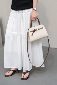 Detail view of a chic cream and brown leather handbag, elegant commuter shoulder style.