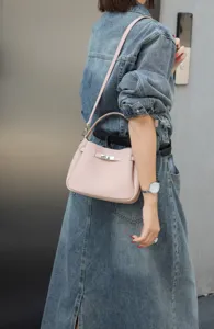 Stylish pink leather mini shoulder bag for women, versatile everyday crossbody handbag style.