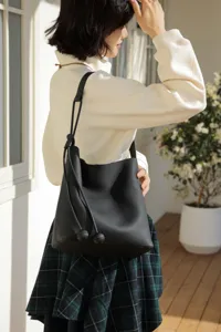 Black leather bucket bag for women, elegant minimalist shoulder handbag with soft pebbled texture.