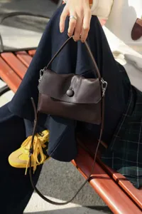 Dark brown genuine leather top-handle crossbody bag with elegant front button closure
