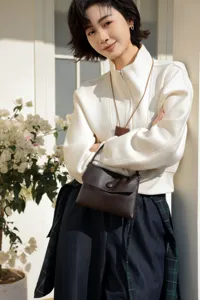 Detailed view of the dark brown genuine leather snap handbag, elegant style for daily use.