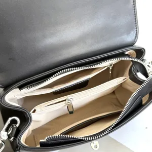 Detailansicht des schwarzen Lederhandtaschen-Innnere mit mehreren Reißverschlussfächern.
