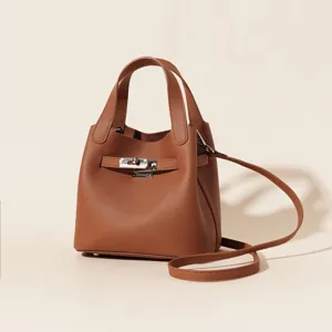 Sac seau classique en cuir véritable avec fermeture à verrou métallique et bandoulière chic.