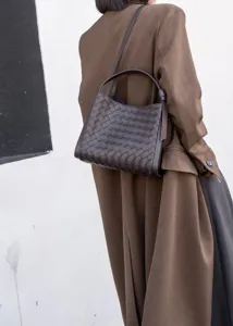 Detail view of premium woven leather shoulder handbag, elegant brown everyday tote design.