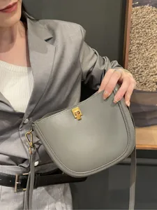 Elegant grey leather saddle bag for women, stylish chic crossbody and shoulder handbag.