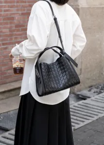 Detailed view of 2025 black woven leather shoulder crossbody bucket bag, elegant fashion style.
