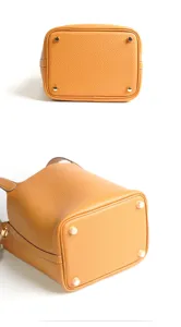 Close-up view of the genuine leather bucket bag bottom showing metal protective feet and texture.