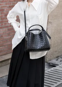 Close-up detail of black woven leather bucket bag, chic daily shoulder and crossbody style.