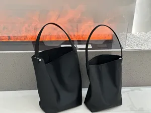 Vista dettagliata della borsa a secchiello in vera pelle nera, grande capacità stile minimalista.