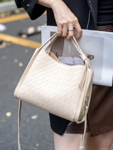 Stylish beige woven leather shoulder bag for women, chic bucket design for spring.