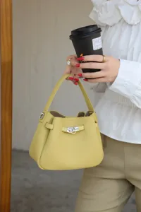 Mini yellow genuine leather Kelly bucket bag, exquisite metal turn-lock detail and top handle.