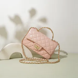 Detailansicht der pinkfarbenen gesteppten Ledertasche mit Metallkettengurt und Drehverschluss.