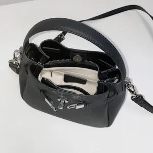 Detail view of the black leather mini bucket bag showing interior pocket and silver hardware.