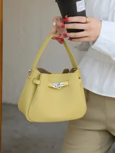Mini leather bucket bag with top handle and turn lock closure, versatile casual crossbody handbag.
