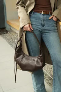 Brown leather pleated hobo bag detail, stylish autumn shoulder dumpling bag for women.